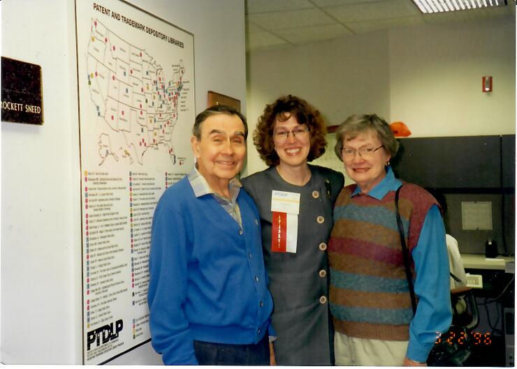 SIS alumna Martha Sneed is pictured with her parents, David and Mary Crockett, at the US Patent and Trademark office in 1996. They are pictured in front of a map of the library network.