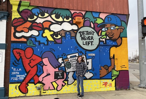 Student Cameron Socha is pictured in front of a colorful mural in the city of Detroit.
