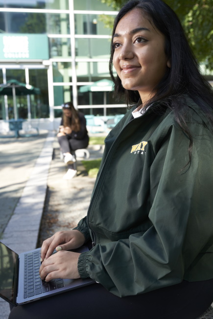 WSU student with laptop on campus