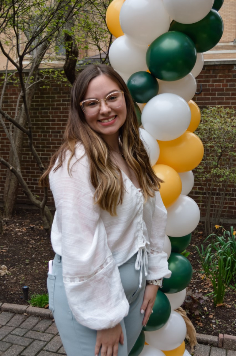 Social work student Samantha Dwornick poses for a photo with balloons.