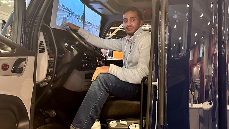 Saeed Ahmad sits in the cab of a new Peterbilt EV truck during the American Trucking Associations’ Trucking U event held in Nashville in October.