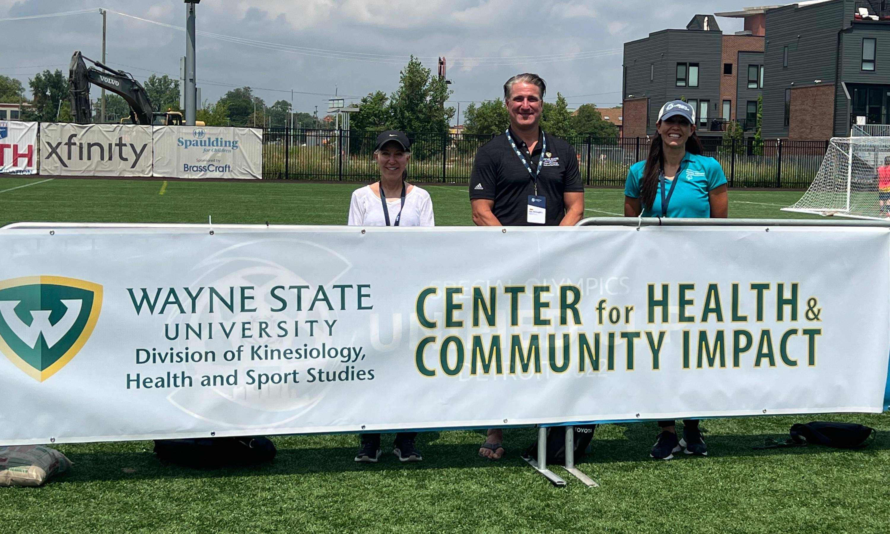 McCaughtry with Ketcheson and Sharon Milberger behind the Center for Health and Community Impact''s banner