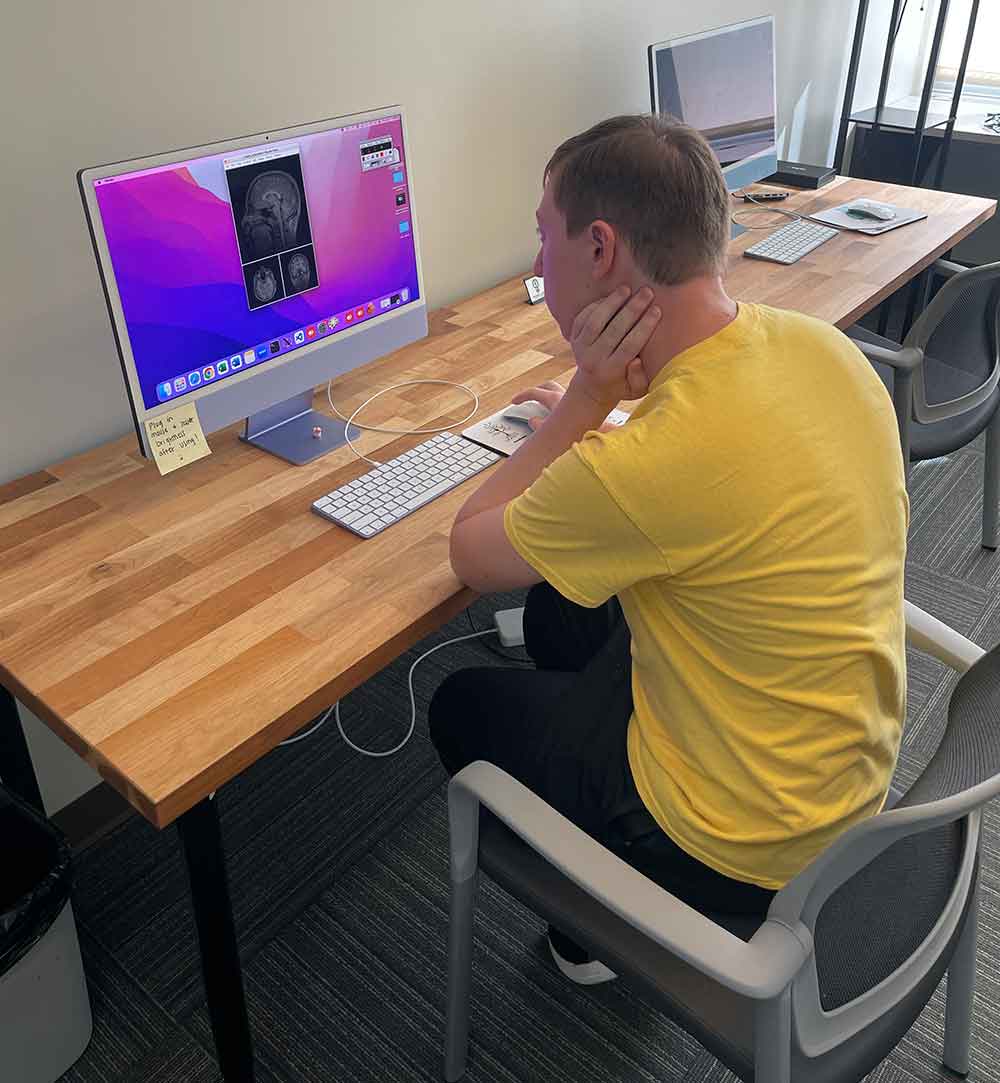 Alexander Jakubiec looking at a brain scan on the computer.