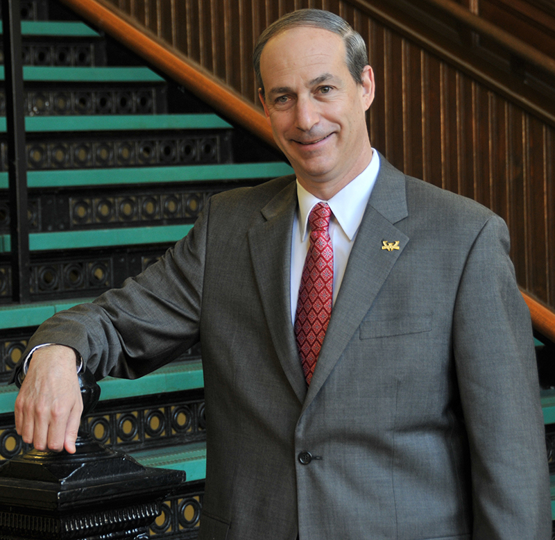 Raskind standing on a stair case in Old Main