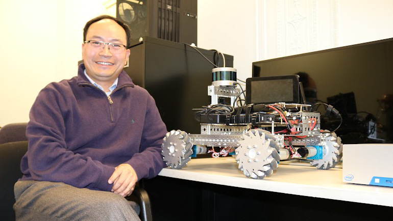 Professor Weisong Shi and a robotic vehicle.