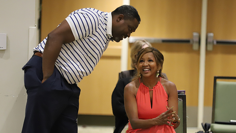 Tyrone Wheatley shares a laugh with Jacqueline Wilson, wife of Wayne State President M. Roy Wilson, before the football coach was introduced at the Board of Governors meeting on June 22.