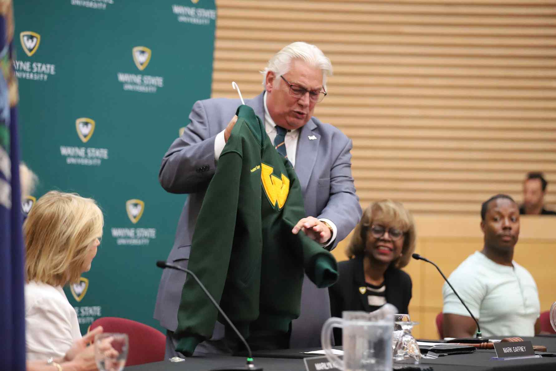 WSU Board Chair Mark Gaffney displays a gift of WSU gear for incoming President Espy. Also pictured are Board members Marilyn Kelly (left), along with Shirley Stancato and Bryan Barnihill (on right of Mark Gaffney).